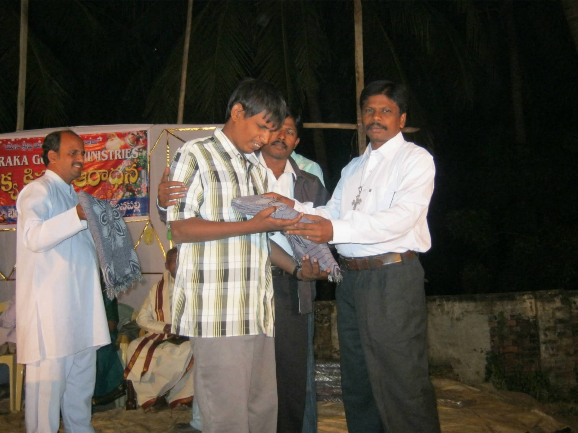 Pastor presenting a shawl to a young blind brother