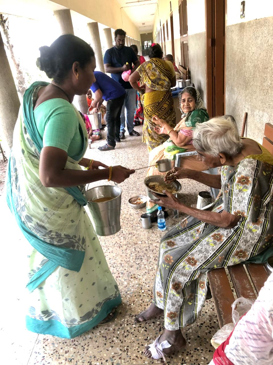 Volunteers serving food to the elderly