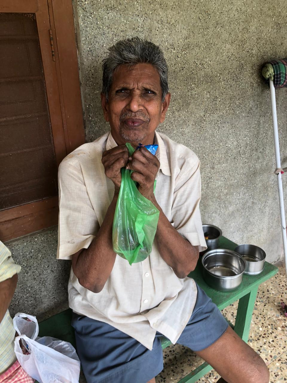 An elderly man holding a relief bag from the ministry